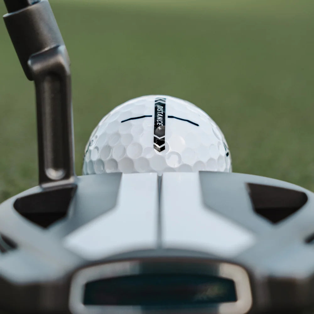 Golf club and golf ball with 'Distance' label on a blurred green background