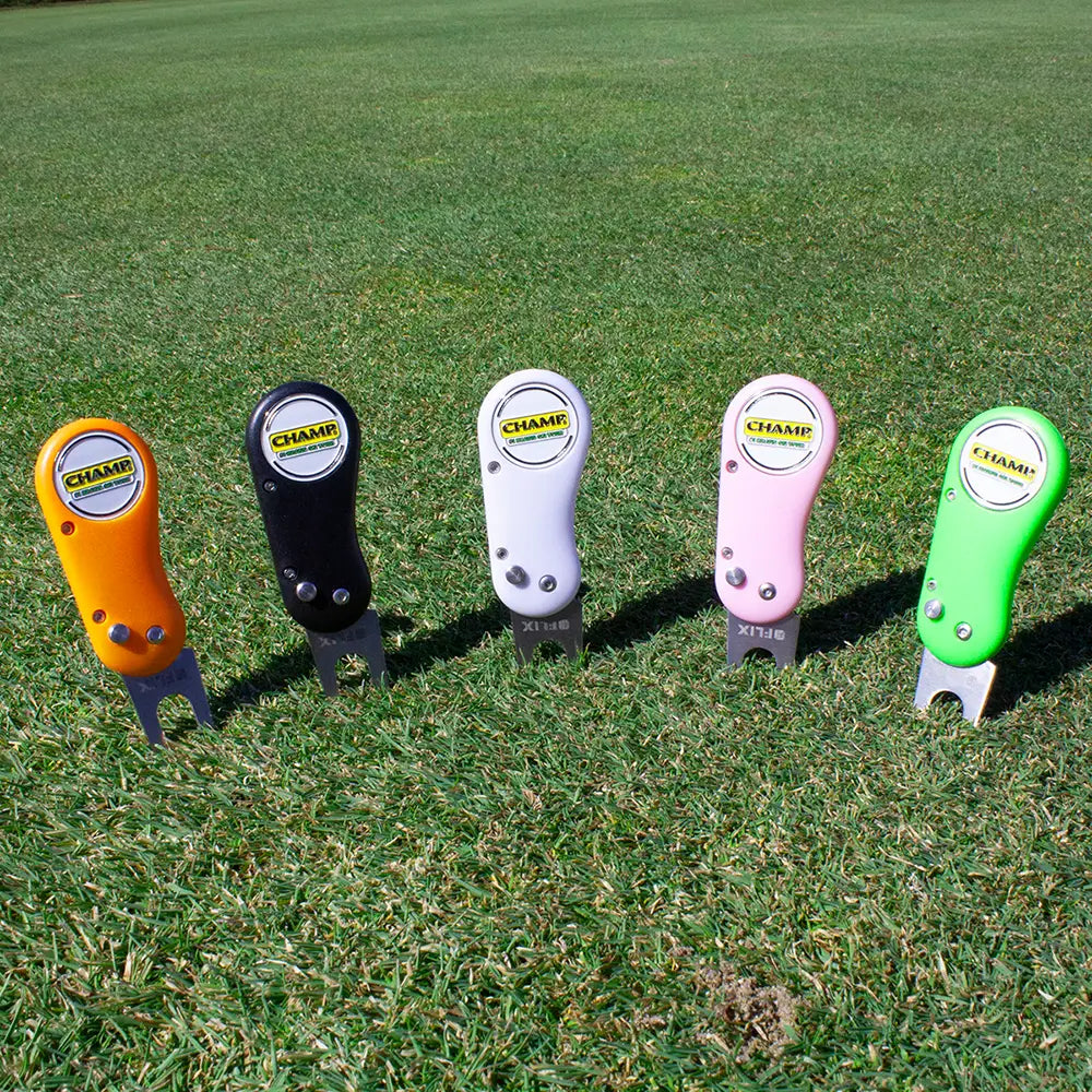 Five colorful golf divot tools on a grassy background