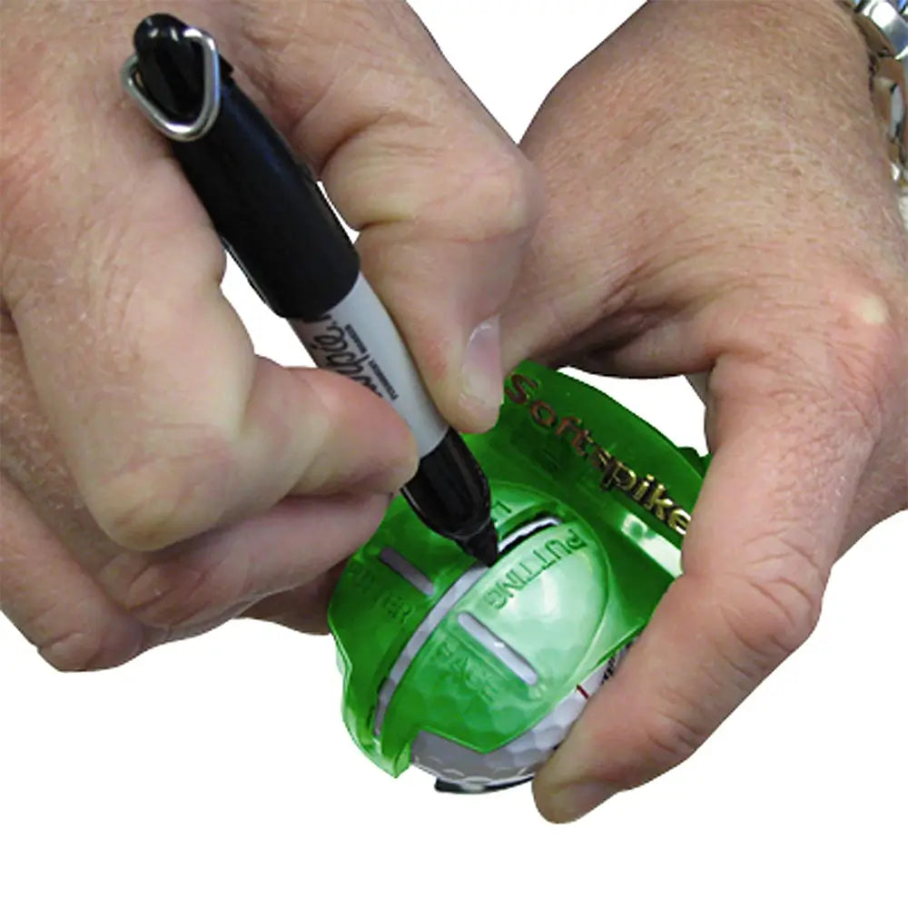 Person marking a golf ball with a marker on a white background