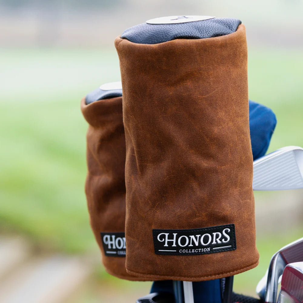 Two brown waxed canvas Barrel Driver Headcovers with black labels reading Honors Collection.